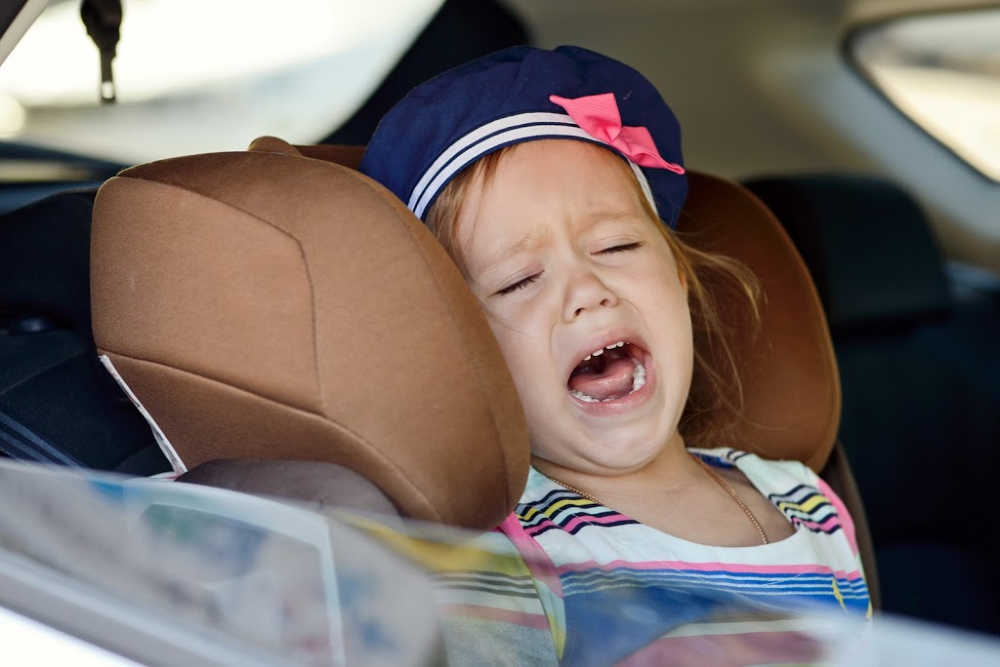 Girl crying in toddler carseat