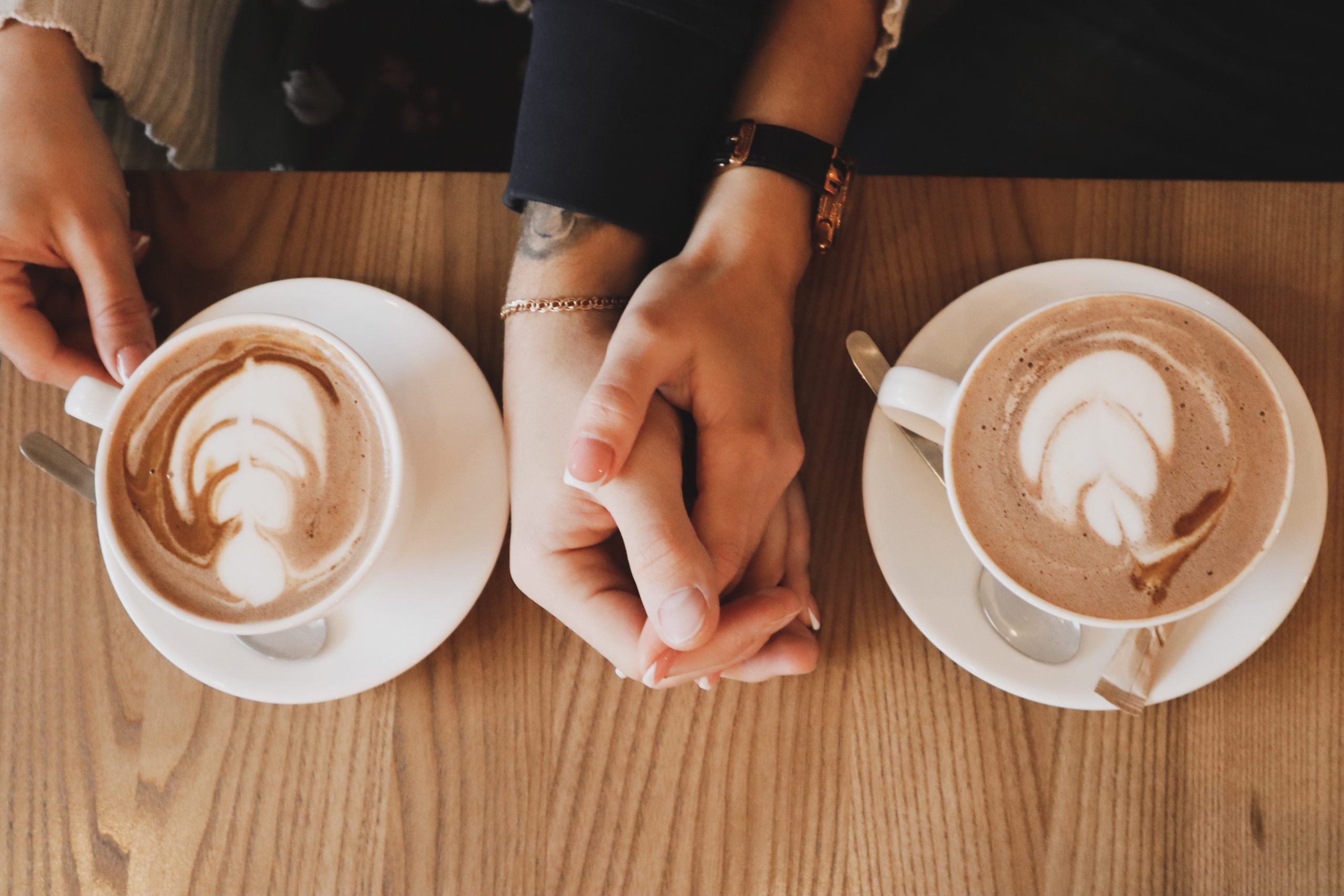 Two hands holding each other, and coffee