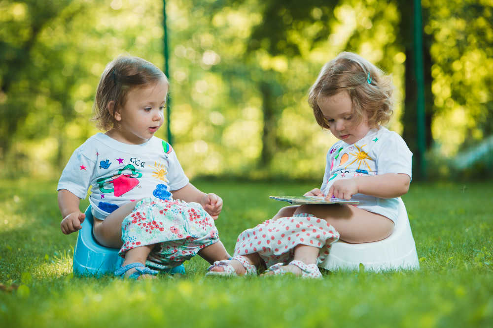 toddler girls read books on the potty