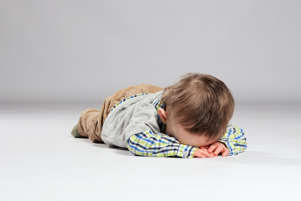 sad toddler boy crying on floor