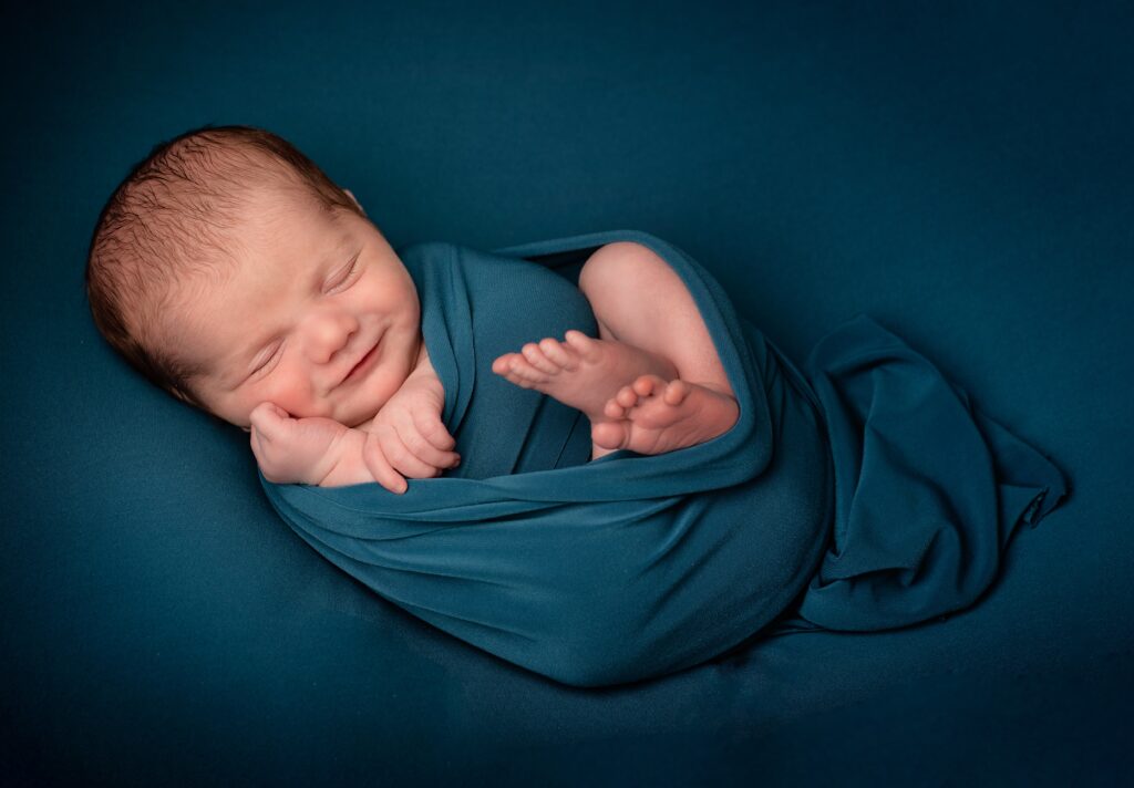 baby wrapped in blue cloth