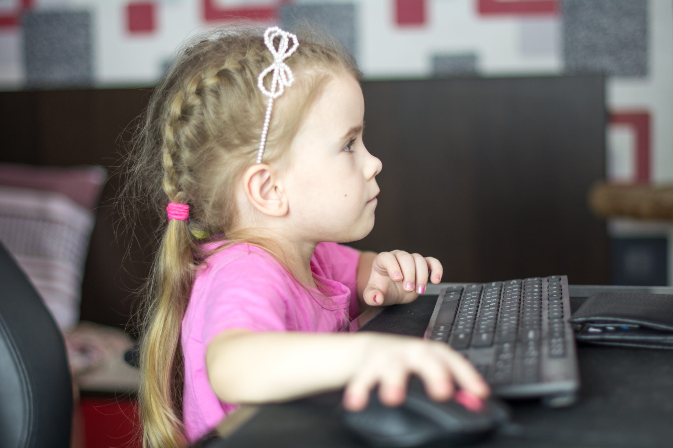 Young girl is playing on a computer