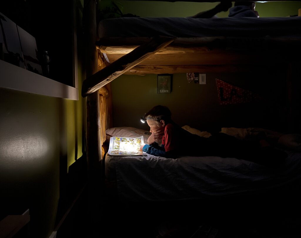 boy reading a comic book in bed