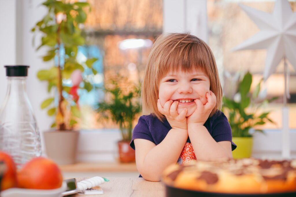 A picky eater is smiling because she has a choice of what to eat for supper.