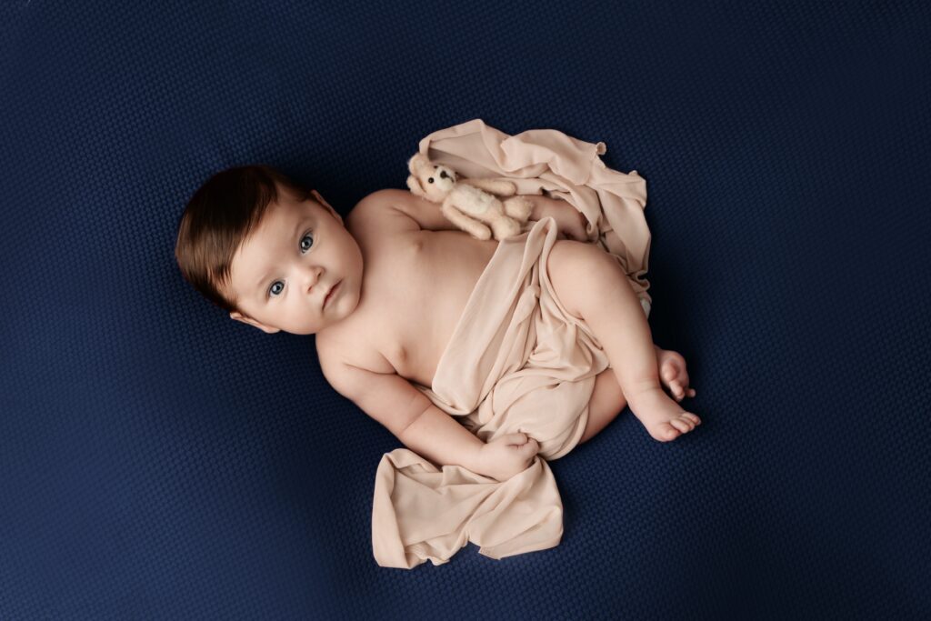 baby lying on a blue blanket