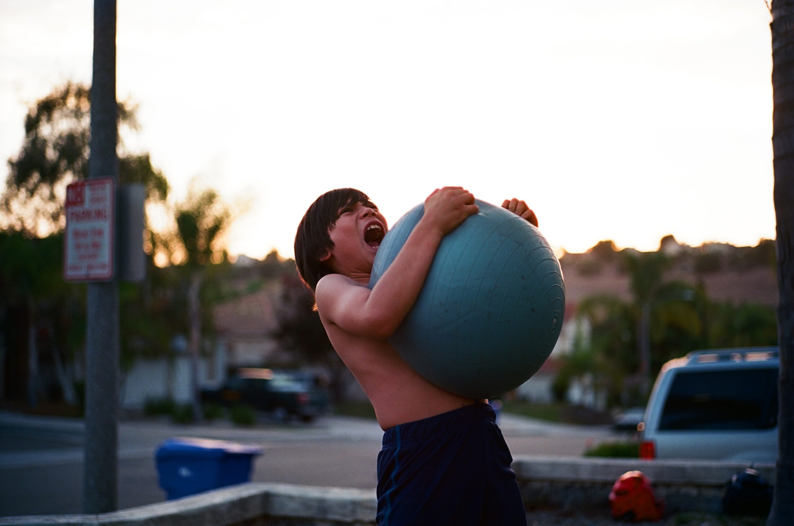 Boy screams while clutching a large ball. Behavioral problems are sometimes a sign of bad parenting.