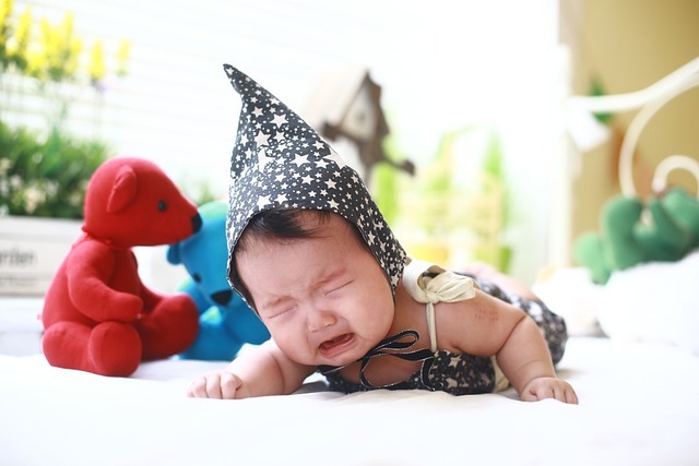 Baby crying on a bed