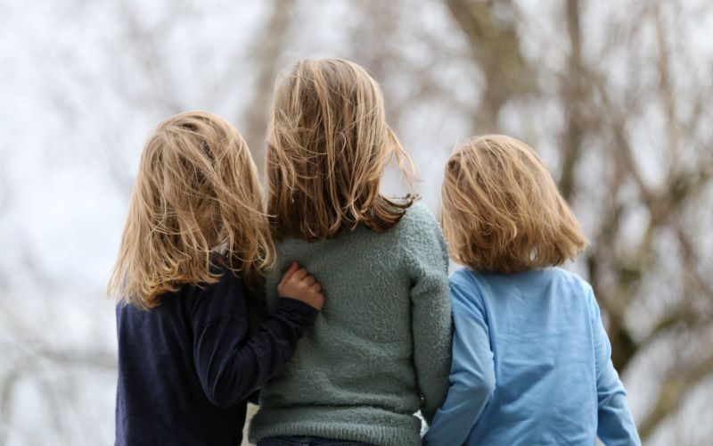 does birth order matter? 3 siblings standing together