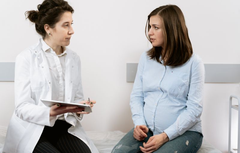 Pregnant woman talks to her doctor about food options that will help with nausea.
