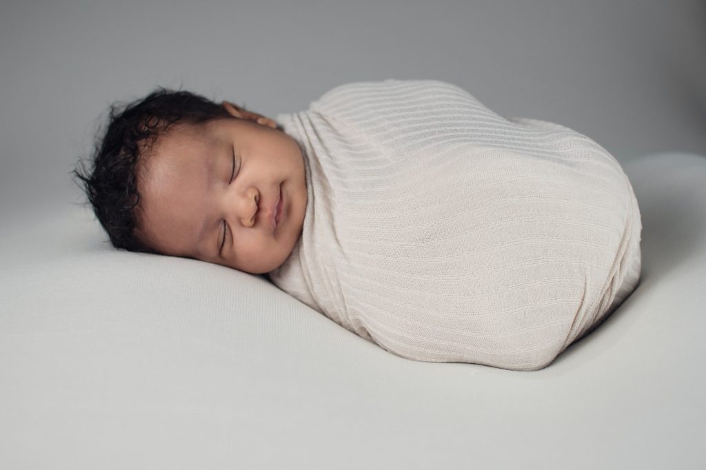 Baby in a white swaddle sleeping soundly