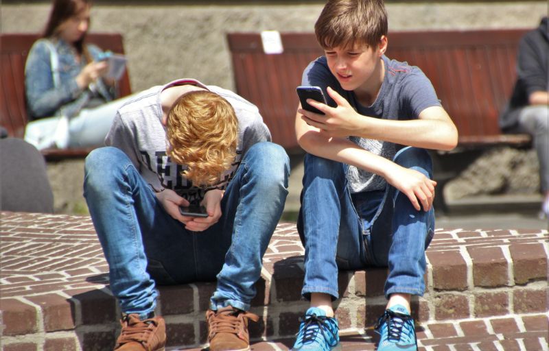 Two teenage boys on their phones