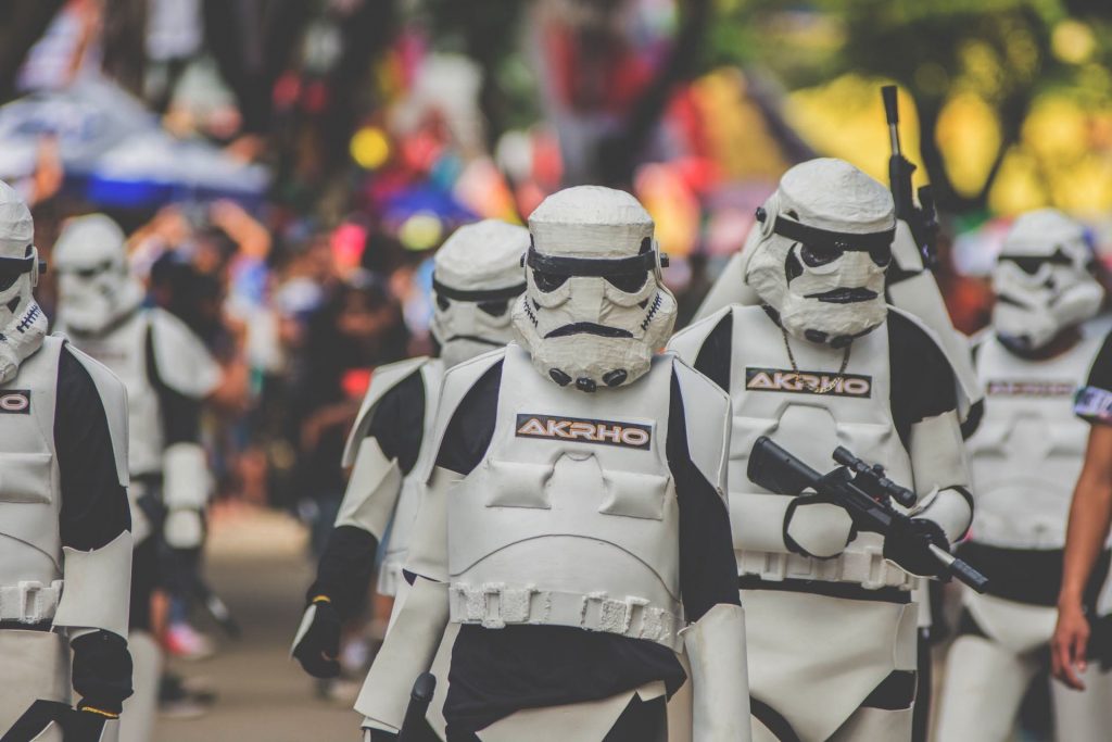 People in storm trooper costumes walk down a street