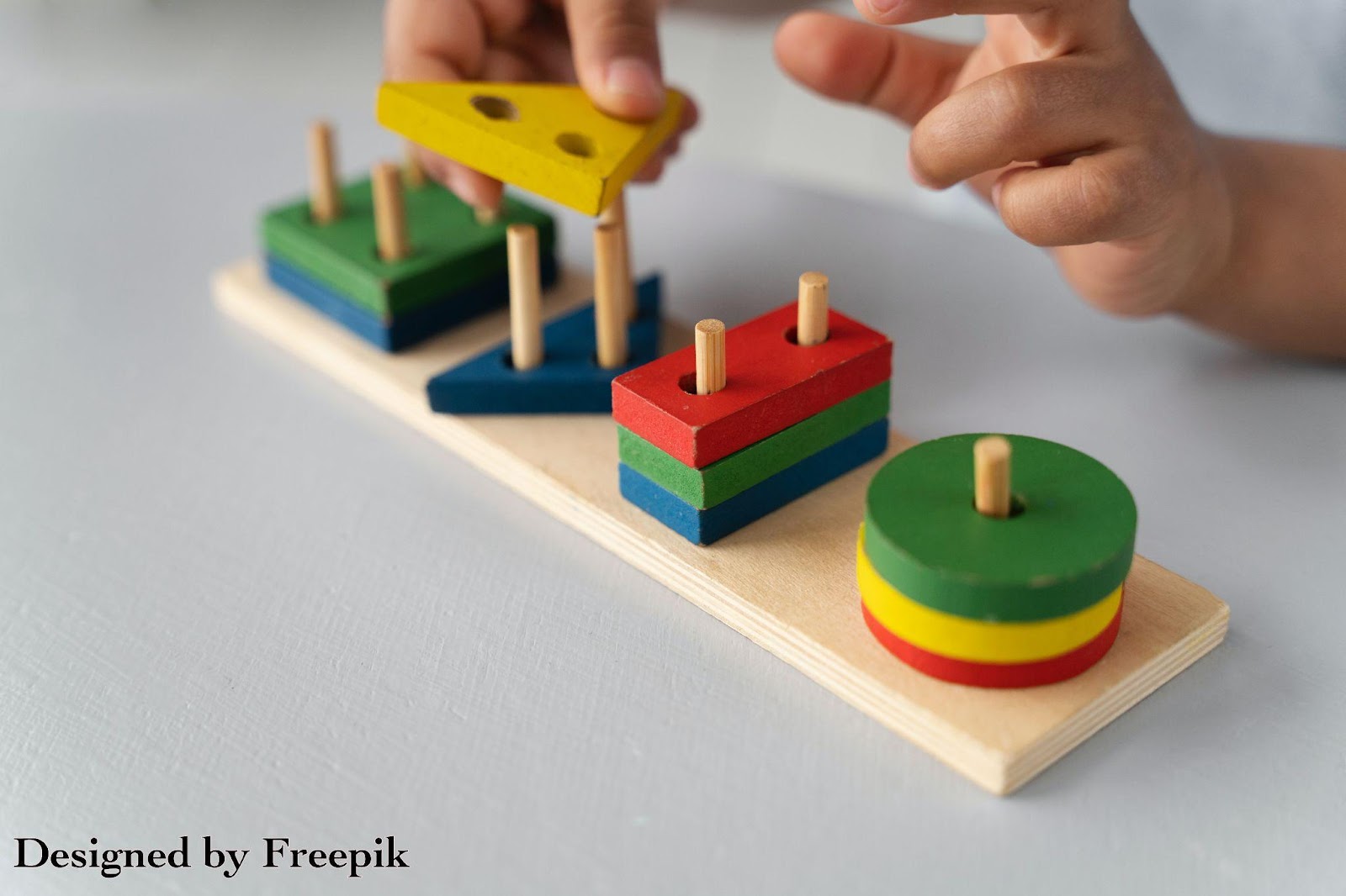 toddler hands playing with a wooden toy
