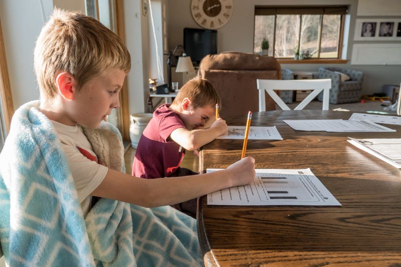 Two boys sitting at a table doing homework 