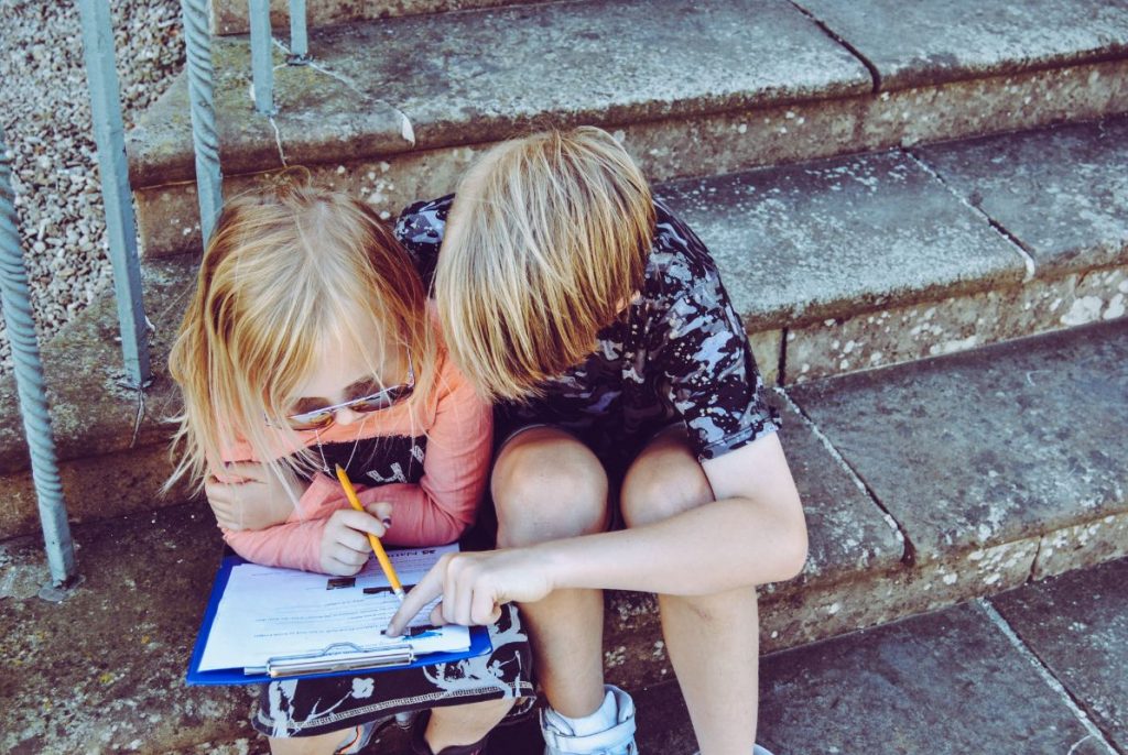 A brother helping his sister with her homework