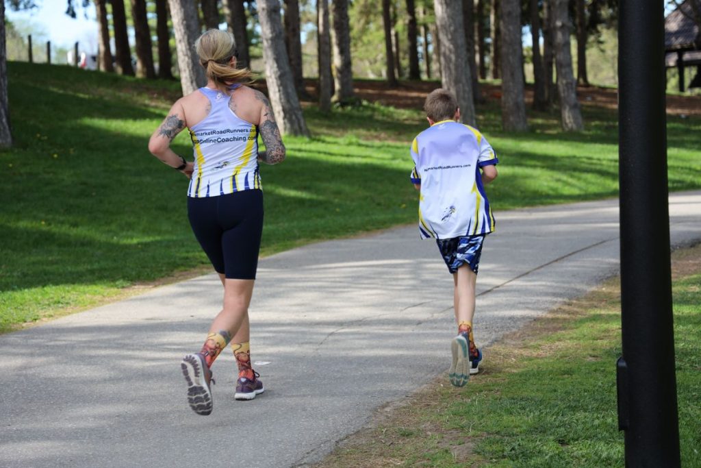 a healthy mother jogging with her son outside. 