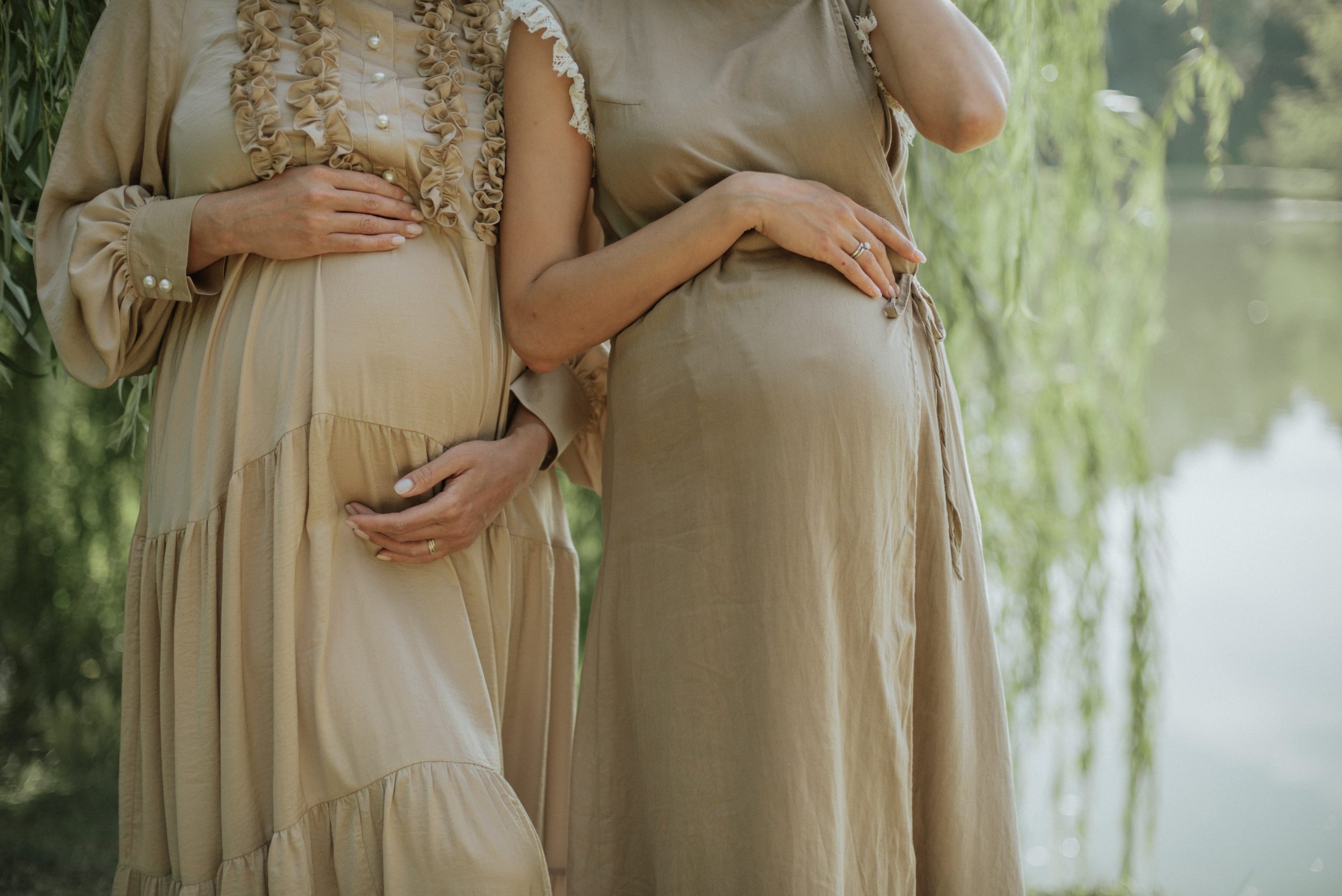 Two pregnant ladies holding their stomachs 
