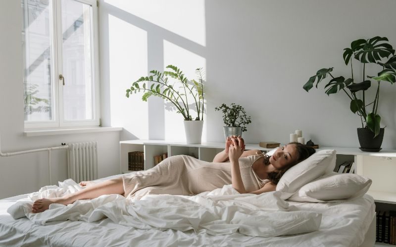 Pregnant Woman laying in bed relaxing