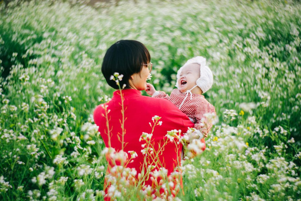 baby and mother in a flower field