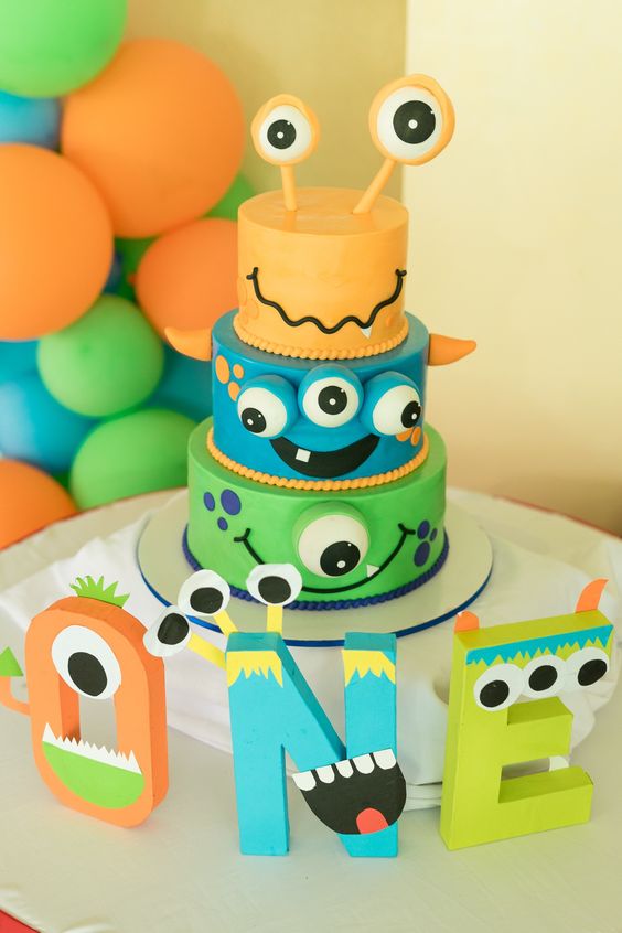 Three-layered monster-theme birthday party cake and designs for kids.