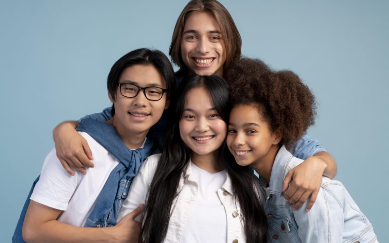Four teens smiling at the camera.