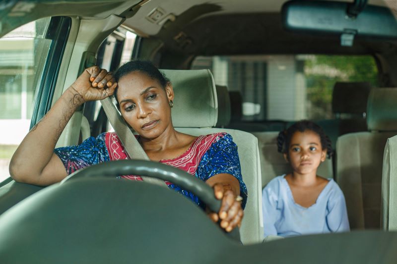 Mother and daughter sitting in a ca r looking upset