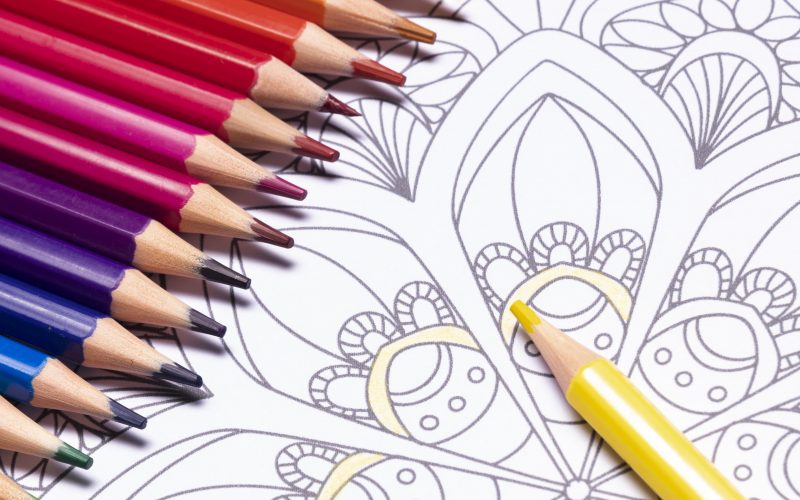 A mandala coloring page and coloring pencils.