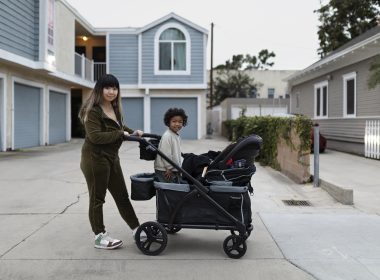 A mom with her son on a stroller wagon.