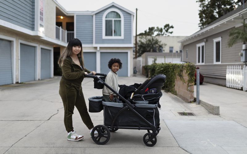 A mom with her son on a stroller wagon.