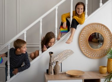 Three kids playing pop it on the stairs.